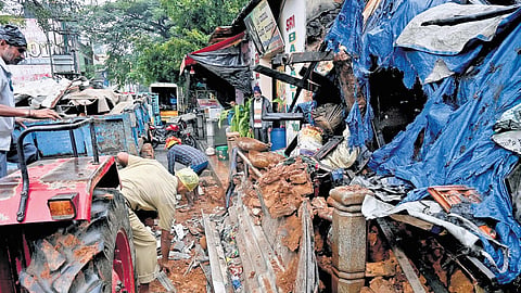 BBMP workers clear the debris at the house collapse site at Chamarajpet in Bengaluru on Monday. No casualties were reported