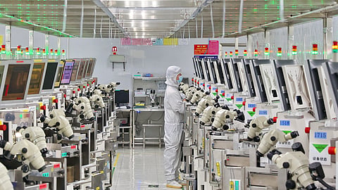 A man works at a manufacturer of Integrated Chip encapsulation in Nantong in eastern China's Jiangsu province.