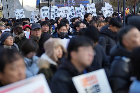 South Koreans hold signs reading "Resign Yoon Suk Yeol" during a rally in Seoul, South Korea, Wednesday, Dec. 4, 2024.