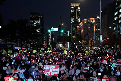 Participants gather to stage a rally demanding South Korean President Yoon Suk Yeol's impeachment, in front of the headquarters of the ruling People Power Party in Seoul, South Korea, Tuesday, Dec. 10, 2024.