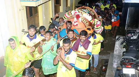 Amid rains, temple employees carry 350-kg drum having cotton threads, along with 600 kg of ghee in 40 tin containers, to the top of the hill