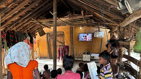 Children watching educator programmes and cartoons on solar television.