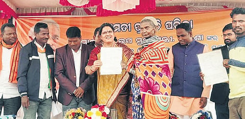 Deputy CM Pravati Parida handing over a land patta to a Bonda woman.