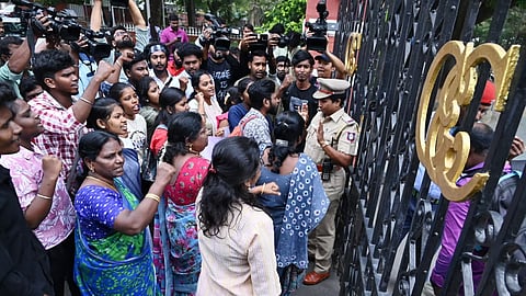 SFI members protest in front of the gate of Anna University campus.