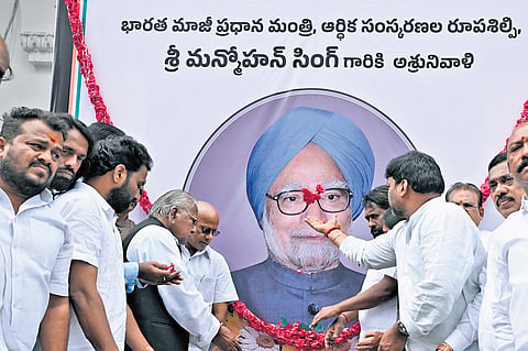 Congress leaders pay tributes to a portrait of former prime minister Manmohan Singh at the Gandhi Bhavan on Friday. A file picture (right) of former CM YS Rajasekhara Reddy and Manmohan Singh at the foundation stone laying ceremony for the Outer Ring Road .
