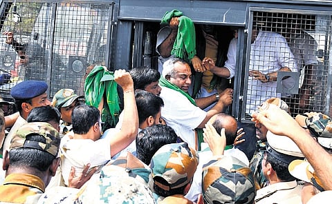 BJP leaders and workers being detained by police in front of Animal Husbandry Minister K Venkatesh’s residence in Mysuru on Tuesday