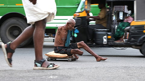 A differently-abled senior citizen navigating through the crowded overbridge junction in Thiruvananthapuram