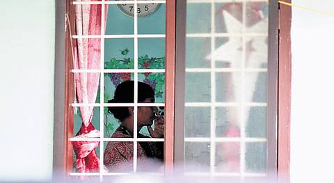 Dhanya, the neighbour of deceased Vinisha, watching news of the murder on the television