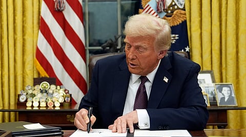 US President Donald Trump signs an executive order in the Oval Office of the White House, Jan. 21, 2025.