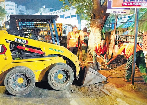 GCC workers deploy a JCB to remove debris and construction waste during the ongoing mass footpath cleaning drive across Chennai