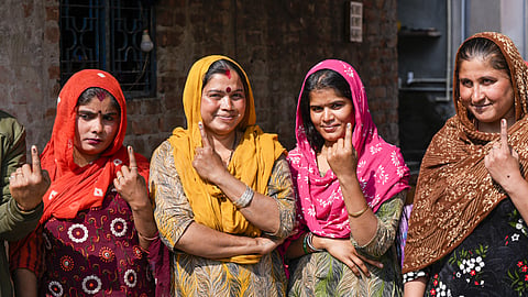 Pakistani Hindu refugees show their fingers marked with indelible ink after casting their votes for the first time during the Delhi Assembly elections, at resettlement colony in Majnu Ka Tila area, in New Delhi, Wednesday, Feb. 5, 2025.