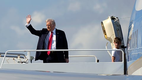 President Donald Trump, left, waves as he boards Air Force One with grandson Theodore, Ivanka Trump's son, at Palm Beach International Airport in West Palm Beach, Fla., Sunday, Feb. 9, 2025.