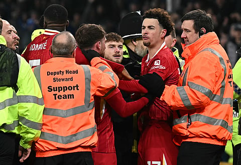 Liverpool's English midfielder Curtis Jones is held back by stewards as he remonstrates with Everton players after the English Premier League match between Everton and Liverpool at Goodison Park (Photo | AFP)
