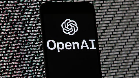 The OpenAI logo appears on a mobile phone in front of a computer screen with random binary data, March 9, 2023, in Boston.
