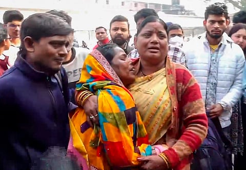 Relatives of victims wait outside the mortuary at the LNJP Hospital, in New Delhi, Sunday, Feb. 16, 2025.