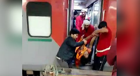 A woman, who fell unconscious, being taken on a trolley from a train, at the New Delhi railway station, Saturday, Feb. 15, 2025.