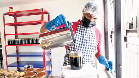 A worker filling the bottle with cane syrup
