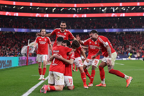 Benfica's Turkish midfielder #10 Orkun Kokcu (C) celebrates with teammates after scoring their third goal during the UEFA Champions League knockout phase play-off second leg football match between SL Benfica and AS Monaco on February 18, 2025.