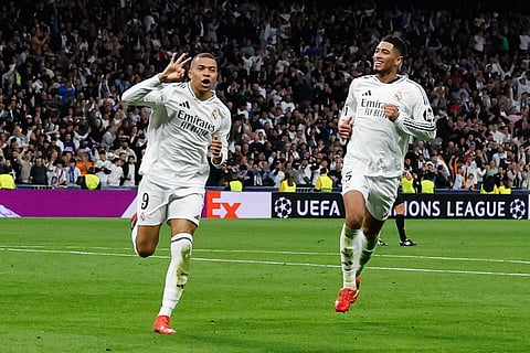 Real Madrid's Kylian Mbappe (L) celebrates scoring his third goal for a hat trick during the UEFA Champions League knockout phase play-off football match between Real Madrid CF and Manchester City on February 19, 2025.