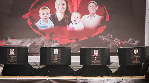 The coffins containing the bodies, from right to left, Shiri Bibas, her two children, Ariel and Kfir and Oded Lifshitz, who was 83 when he was abducted, are displayed on a stage in Khan Younis, southern Gaza Strip, Thursday, Feb. 20, 2025.