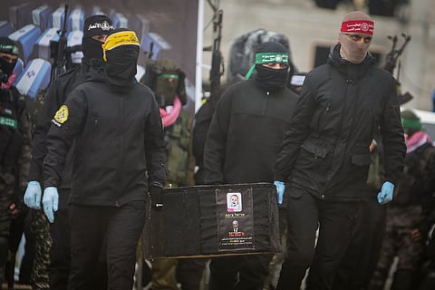 Hamas members carry a coffin containing the body of Kfir Bibas as the remains of four bodies are handed over to the Red Cross in Khan Younis, southern Gaza Strip, Thursday, Feb. 20, 2025.