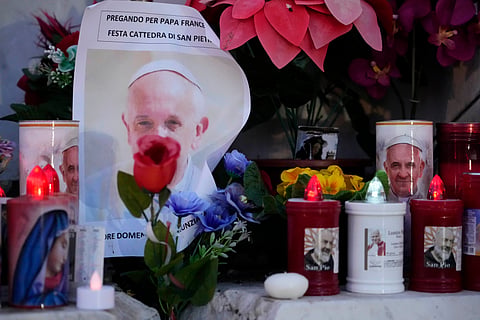 Candles are seen near pictures of Pope Francis outside the Agostino Gemelli Polyclinic in Rome, Sunday, Feb. 23, 2025, where the pontiff has been hospitalised since Feb. 14.