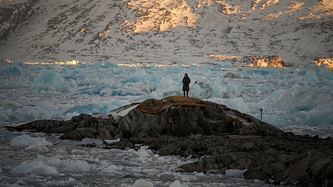 A resident watches as pieces of ice pile up blocking the access of the port of Nuuk, Greenland, Tuesday, Feb. 18, 2025.