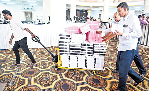 Staff move budget-related material in Vidhana Soudha on Thursday.