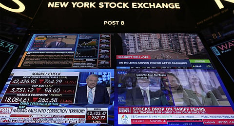 Financial news is displayed as people work on the floor at the New York Stock Exchange in New York, Tuesday, March 4, 2025.