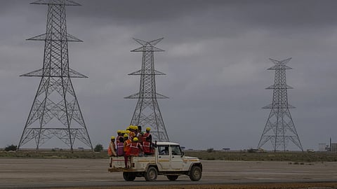 Workers travel in a vehicle toward the construction site of Adani Green Energy Limited’s Renewable Energy Park in the salt desert of Karim Shahi village, near Khavda, Bhuj district near the India-Pakistan border in the western state of Gujarat, India, on Sept. 21, 2023.
