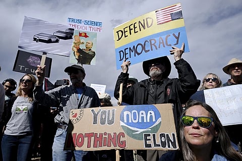 Susie House, front, and David Hill hold up signs as they join hundreds of others during a large rally and protest outside the National Oceanic and Atmospheric Administration campus Monday, March 3, 2025, in Boulder, Colo.