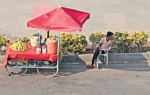 A juice vendor waits for customers on a sunny day in Hyderabad