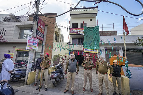 Police personnel stand guard in front of a temple after an alleged blast here, in Amritsar's Khandwala area, Saturday on March 15, 2025.