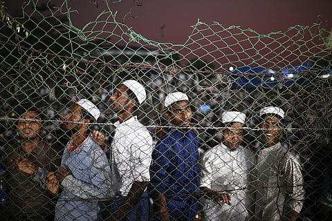 Rohingya refugees gather behind a fence to look at UN Secretary -General António Guterres who visited the Ukhiya camp in Cox's Bazar, in Bangladesh, Friday, March 14, 2025.