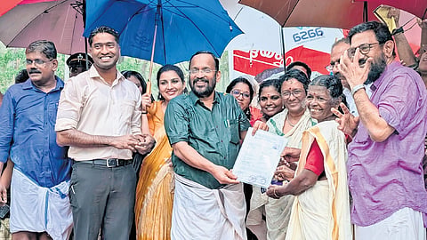 Revenue Minister K Rajan handing over the land deed to Madhavi Kuttappan, head of Olakara Unnathi.