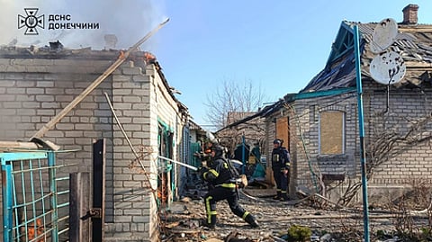 In this photo provided by the Ukrainian Emergency Service, firefighters put out the fire following a Russian attack in Donetsk region