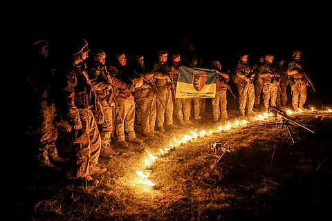 In this photo taken on March 21, 2025 and provided by Ukraine's 24th Mechanized Brigade press service on March 24, 2025, servicemen attend a dedication ceremony for soldiers near the frontline in the Donetsk region, Ukraine.