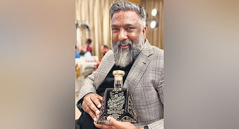 Tonnit Thomas holds the Expedition edition of the whisky bottle designed by him