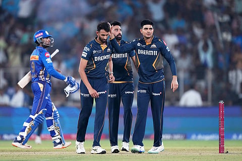 Gujarat Titans' Prasidh Krishna, second left, is congratulated by captain Shubman Gill after the dismissal of Mumbai Indians' Tilak Verma (Photo | AP)