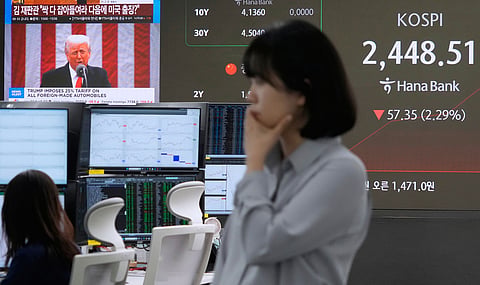U.S. President Donald Trump is seen on a screen as a currency trader works at the foreign exchange dealing room of the KEB Hana Bank headquarters in Seoul, South Korea, Thursday, April 3, 2025.