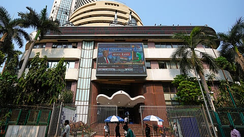 People watch the stock market index on a display screen on the facade of the Bombay Stock Exchange (BSE) building in Mumbai, India, Thursday, April 3, 2025.