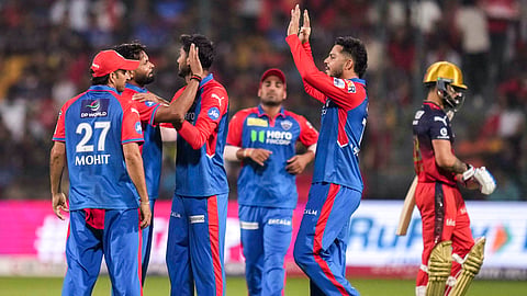 Delhi Capitals' Mukesh Kumar celebrates with teammates after taking the wicket of RCB's Devdutt Padikkal during an IPL 2025 T20 cricket match between RCB and Delhi Capitals, at the M Chinnaswamy Stadium, in Bengaluru, Karnataka, Thursday, April 10, 2025.