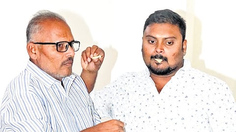 Kunamaneni Teja Sai and his father Srinivas Rao share sweets in Sangareddy district on Saturday