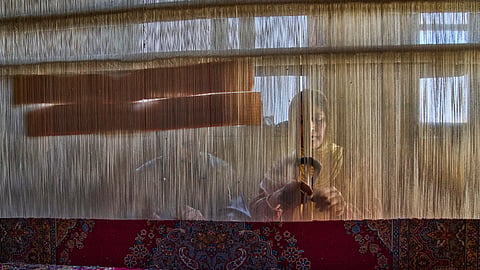 Shameema and her husband, Mohammad Yousaf Dar, weave a Kashmiri hand-knotted carpet at their home in Srinagar on April 15, 2025.