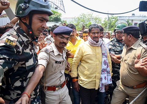 Security personnel escort Rashtriya Janata Dal (RJD) MLA Ritlal Yadav who surrendered before the Danapur Court in connection with an extortion case, in Patna, Thursday, April 17, 2025