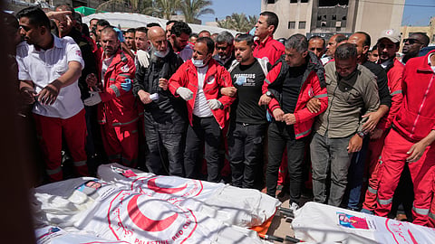 Mourners gather around the bodies of 8 Red Crescent emergency responders, recovered in Rafah a week after an Israeli attack, as they are transported for burial from a hospital in Deir al-Balah, Gaza Strip, on Monday, March 31, 2025.