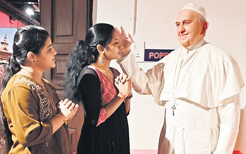 Faithful seek blessings before a wax statue of Pope Francis at Sunil’s Wax Museum, Thiruvananthapuram