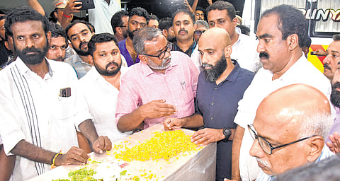 Aravinda Menon, son of N Ramachandran, receives the mortal remains of his father at Kochi airport on Wednesday. Agriculture Minister P Prasad (left) and Aluva MLA Anwar Sadath (right) are seen. The body will be kept at Changampuzha Park from 7am to 9am on Friday for the public to pay homage. The cremation will be carried out at the crematorium near Edappally at noon
