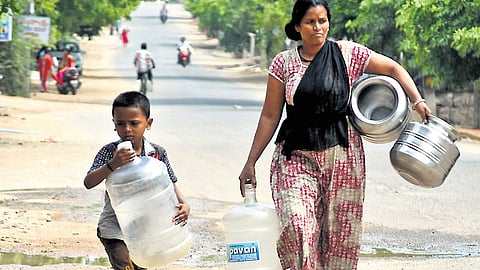 A woman and her son, with empty cans in hand, go to fetch water in Karimnagar. The rising temperatures have pushed up demand for water across the state