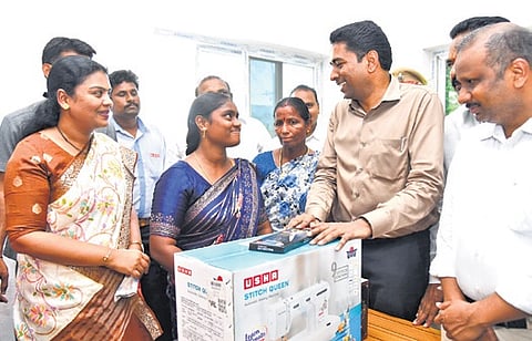 NTR Collector Lakshmisha distributes a sewing machine to a woman